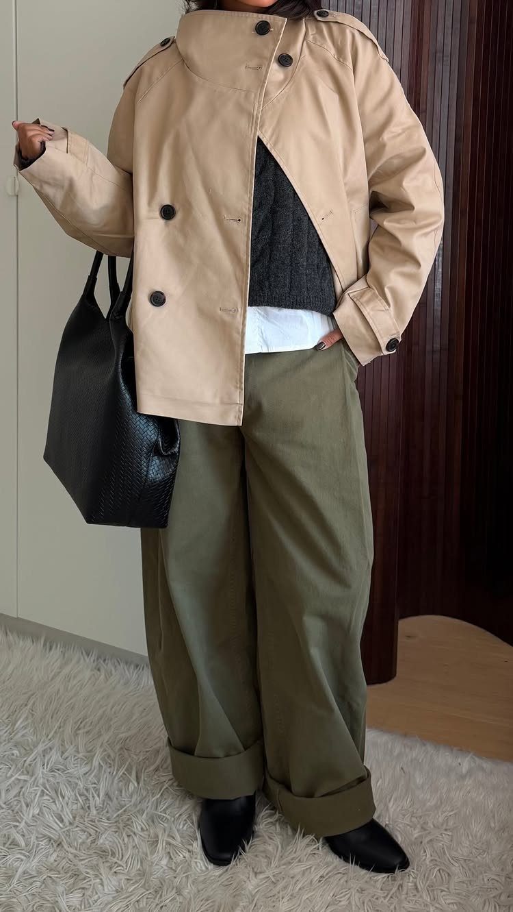 Woman wearing an oversized beige jacket, grey sweater, and olive green wide-leg trousers.