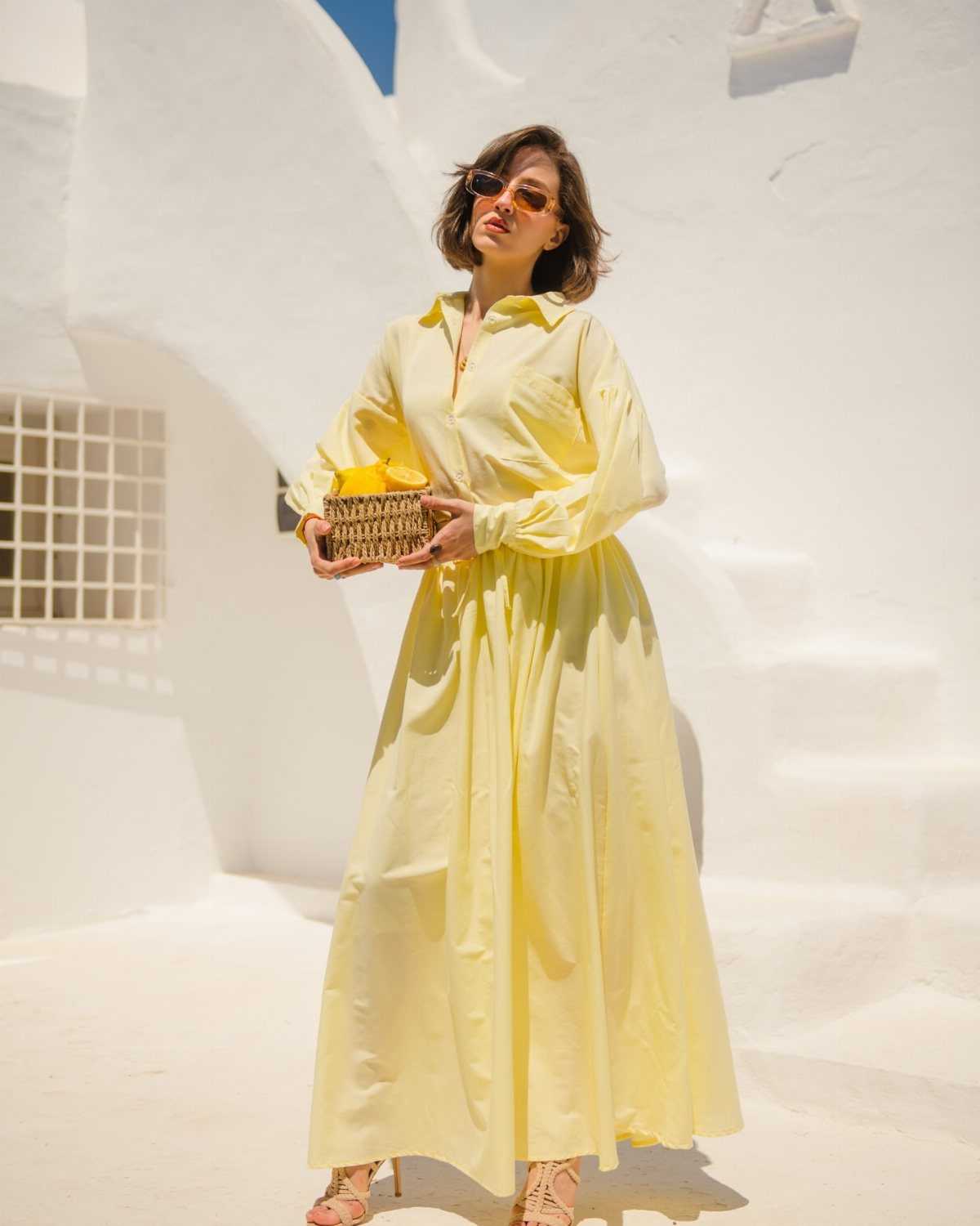 Woman wearing a coordinated yellow button-down shirt and long maxi skirt outdoors.